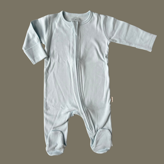 A blue organic cotton baby footie with a 2-way zipper and elastic ankle cuffs.