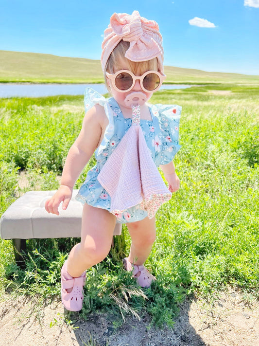 Baby with pacifier blanket and flower pacifier