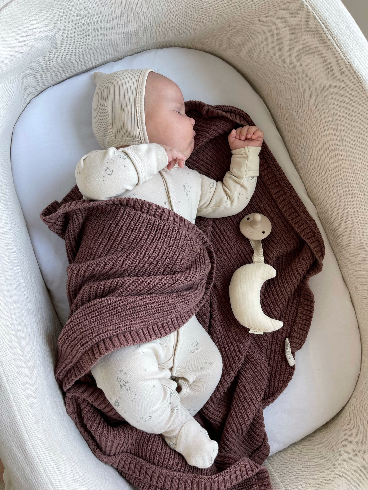 Baby sleeping inside basinet with Ali+Oli baby products